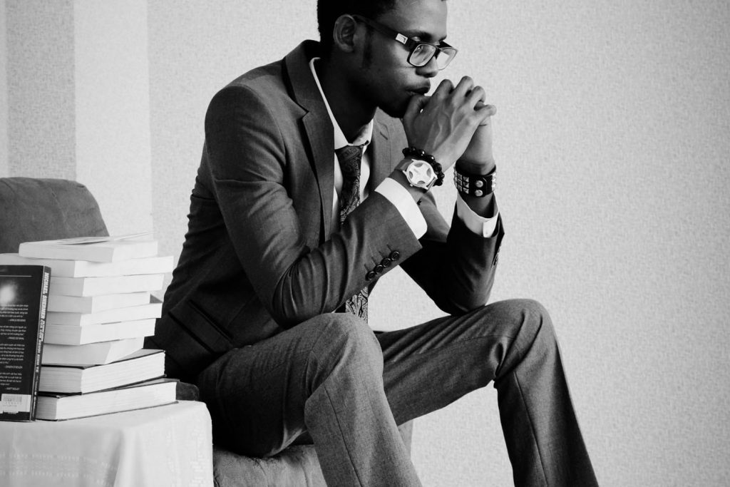Young man sitting on the chair holding his hands