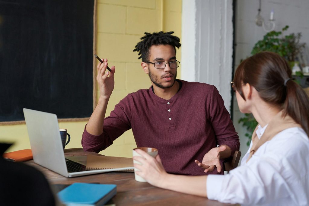 Two young adults talking in a room
