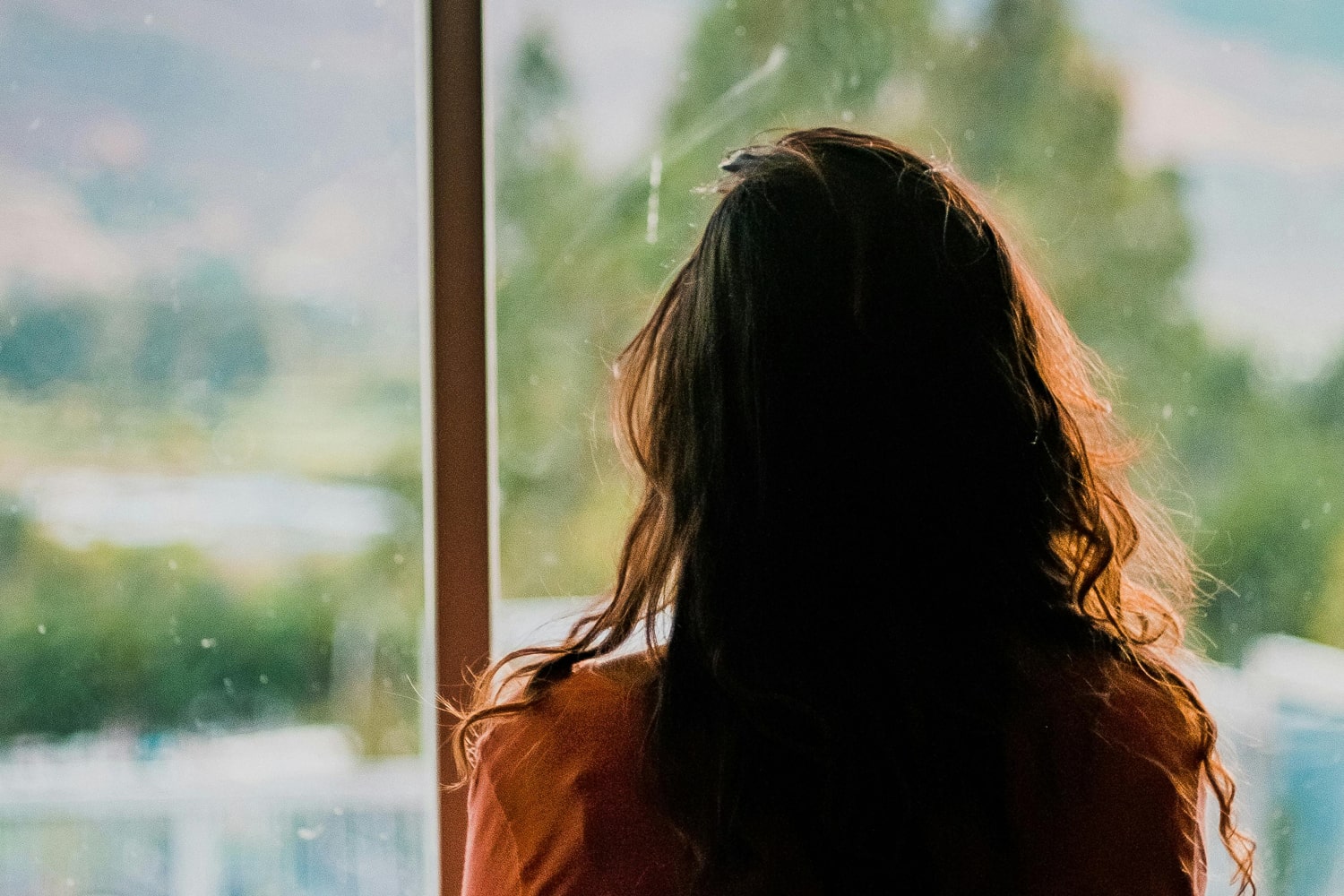 Woman stares out the window thinking
