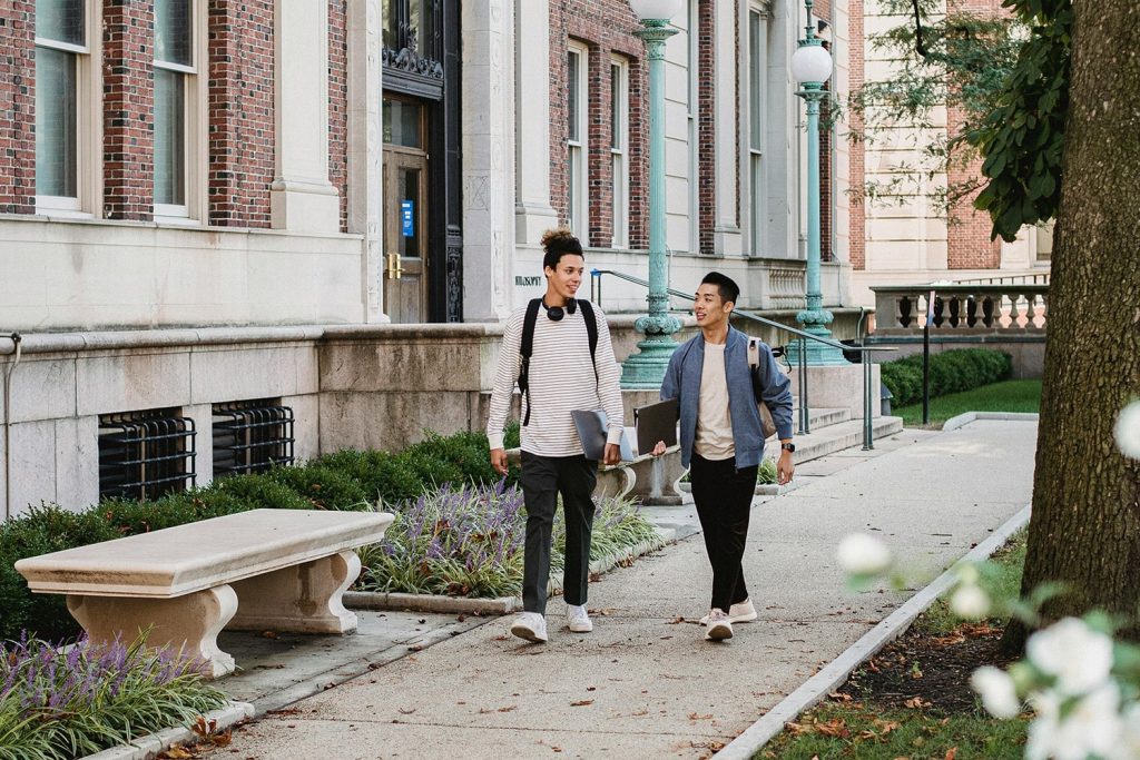 Two students walking around a small town college campus