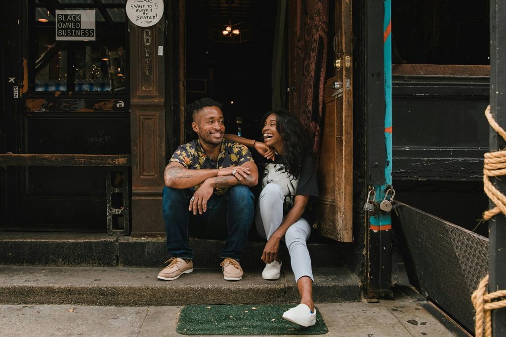 Two friends laughing near the store entrance