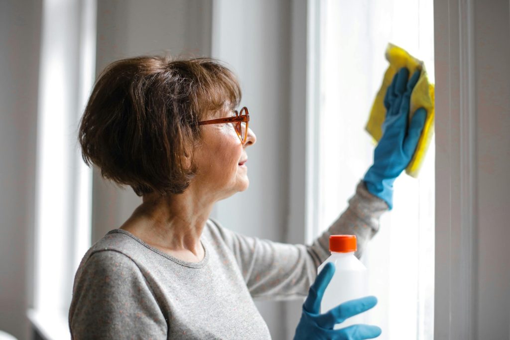 Woman cleaning windows of a house