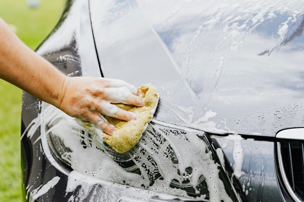 Side view of a man detailing his car
